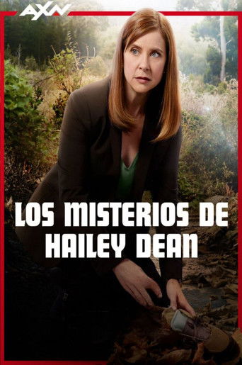 The poster features Hailey Dean in a dramatic pose, her gaze intense and serious. She wears a dark blazer over a green top, with her hands resting on a rocky surface. The background is a lush, green forest, suggesting mystery and intrigue. The bold white text "LOS MISTERIOS DE HAILEY DEAN" domina...