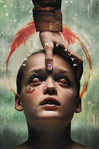 The poster features a young girl with pale skin and dark eyes, her face framed by a swirling red halo. A gloved hand reaches down to touch her forehead, creating a sense of connection or danger. The background is a muted green with subtle white speckles, evoking a mysterious and eerie atmosphere.