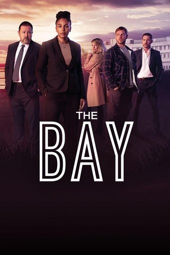 The Bay poster features five men in formal suits against a dramatic sunset backdrop, evoking mystery and sophistication. The warm tones of the sky contrast with the cool, dark suits, creating a visually striking composition that suggests intrigue and tension.