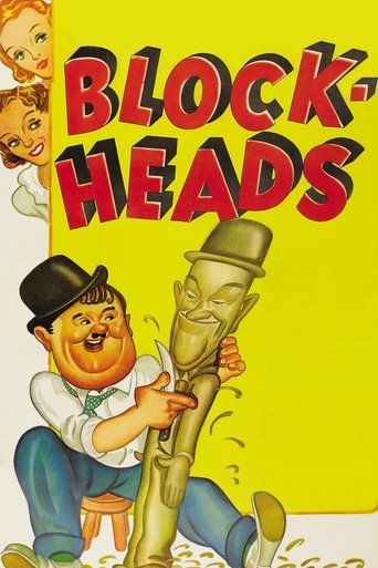 The poster features a cheerful man in a black hat and white shirt holding a large, menacing golden head. The title "BLOCK HEADS" is prominently displayed in bold red letters against a bright yellow background. The overall mood is playful yet sinister, suggesting a dark comedy or horror genre.