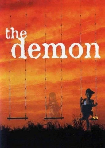 The movie poster features a silhouette of a man holding a lantern against a vibrant sunset sky. A ghostly figure floats in the distance, adding an eerie atmosphere. The title "the demon" is prominently displayed in bold white letters, evoking mystery and suspense.