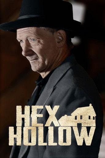 The poster features a man in a black hat and suit, exuding mystery and intrigue. The title "Hex Hollow" is prominently displayed in bold, golden letters, with a small illustration of a house nestled within the text. The warm, sepia-toned background adds to the eerie atmosphere, suggesting a dark ...
