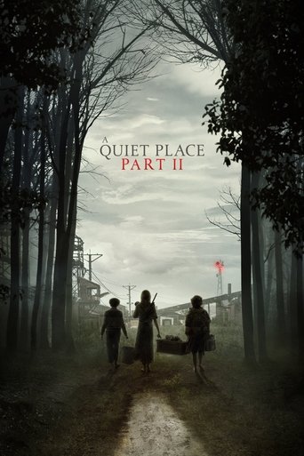 The poster depicts three figures walking through a misty forest, their silhouettes framed by tall, bare trees. The muted, gray tones and low light create a somber, eerie atmosphere. The title "A Quiet Place Part II" is prominently displayed in stark white text, emphasizing the horror genre.