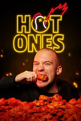 The poster features a bald man with a grumpy expression, eating a piece of fried chicken. The title "HOT ONES" glows in neon yellow against a dark background, with sparks and flames surrounding it. The overall mood is humorous and energetic, capturing the essence of a fun, spicy food show.