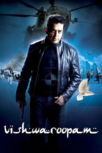 The poster features a man in a leather jacket standing against a dark, stormy sky with helicopters and soldiers in the background. The colors are cool blues and dark tones, creating a mysterious and tense atmosphere. The title "Vishwaroopam" is written in white at the bottom.