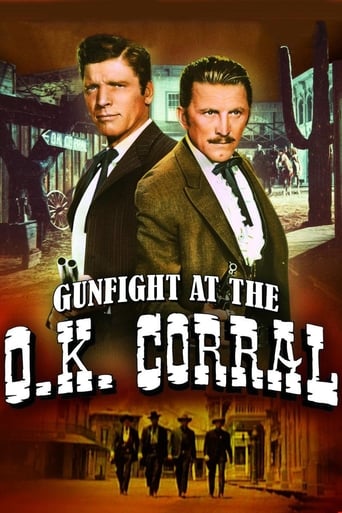 The poster features two men in suits against a warm, sepia-toned background, evoking a classic Western atmosphere. Below them, silhouettes of figures march toward a grand building, suggesting action and tension. The title "Gunfight at the O.K. Corral" is boldly displayed in white, contrasting sha...