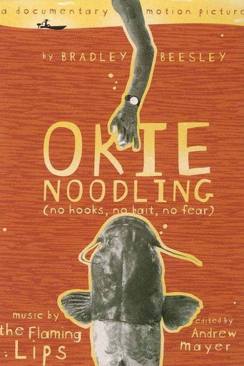 The poster features a hand reaching out from the top, symbolizing hope and connection. The warm orange background evokes a cozy, inviting atmosphere. The title "Okie Noodling" is prominently displayed in bold, playful lettering. This visually evokes themes of resilience, community, and the enduri...
