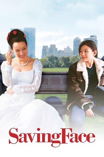 The movie poster features two women sitting on a park bench, with one in a white dress and the other in a brown coat. The city skyline and greenery provide a serene backdrop, while the red title "Saving Face" adds a touch of drama. The mood is reflective and slightly melancholic, capturing the es...