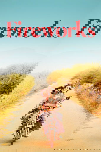 A couple rides a bicycle down a sun-drenched road, surrounded by golden fields and vibrant greenery. The poster features bold red text against a clear blue sky, evoking a sense of joy and freedom.