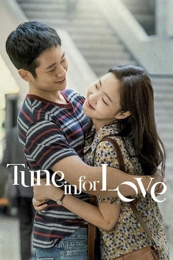 The poster captures a tender moment between two people embracing warmly, with soft lighting enhancing the intimate atmosphere. The couple's expressions convey deep affection and connection, while the muted tones of the clothing and background create a romantic and nostalgic mood. The title "Tune ...