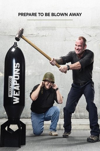 A dramatic scene depicts two men in a gritty, industrial setting. One man in a black shirt and jeans holds a large hammer, while another in a green cap and jeans crouches behind a black "Weapons" canister. The poster features bold text at the top, emphasizing the theme of preparation for destruct...
