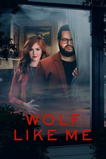 The poster features a dramatic scene with two characters in a moody, atmospheric setting. The woman with red hair and the man with glasses are framed against a dark, smoky background, evoking a sense of mystery and intrigue. The title "Wolf Like Me" is prominently displayed in bold, red letters, ...