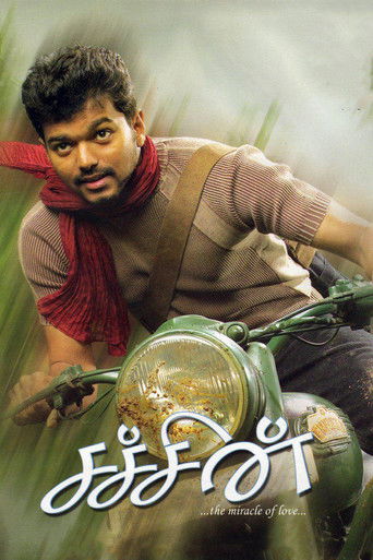 The poster features a man in a brown sweater and red scarf riding a green motorcycle, with a dreamy, ethereal background. The title "Sachein" is written in white script at the bottom, conveying a sense of adventure and nostalgia.