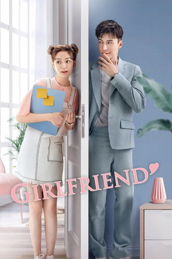 The poster features a stylish couple standing in a bright, airy room. The woman wears a light blue dress with a yellow purse, while the man dons a light gray suit. The soft pastel colors and clean lines evoke a romantic, modern atmosphere. The title "Girlfriend" is elegantly displayed in pink tex...