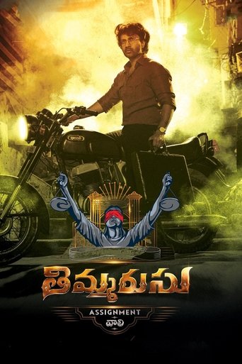 The poster features a rugged man on a motorcycle against a fiery, dramatic backdrop. The title "Thimmarusu: Assignment Vali" is prominently displayed in bold, golden letters. The overall mood is intense and adventurous, with warm colors like orange and yellow evoking a sense of action and danger.