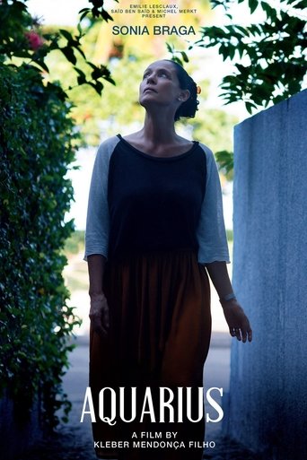 The poster features a woman in a black top and brown skirt, gazing upward with a serene expression. She stands against a backdrop of lush greenery and a textured wall, evoking a sense of calm and introspection. The title "Aquarius" is prominently displayed at the bottom, suggesting themes of myst...