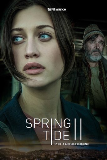 The poster features a close-up of a woman with striking blue eyes, her expression conveying mystery and intrigue. Behind her, an older man in a hat adds depth to the scene. The muted earthy tones and shadowy background create a somber, atmospheric mood, suggesting a suspenseful narrative. The tit...