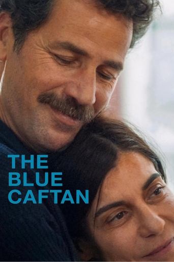The poster features a close-up of two individuals, one with a mustache and the other with short hair, both looking downward with a somber expression. The blue text "THE BLUE CAFTAN" stands out against the muted tones of the image, evoking a sense of melancholy and introspection.