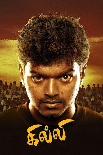 The poster features a close-up of a man with intense eyes, set against a warm sunset backdrop. Below him, the title "Ghilli" is written in bold, golden script. The overall mood is dramatic and mysterious, suggesting a thrilling adventure story.