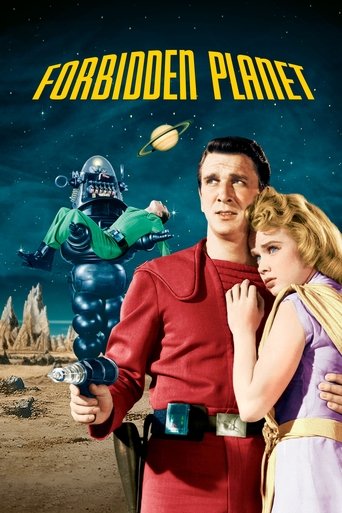 The poster features a man in a red uniform holding a green alien robot, with a woman in purple and a man in a blue suit embracing them. The background shows a desert landscape with a planet and a space station, evoking a space adventure mood.