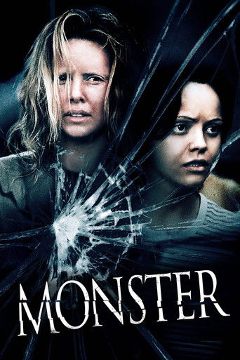 The poster features two women with intense, fearful expressions against a dark, ominous background. A shattered glass effect dominates the center, symbolizing danger and destruction. The title "MONSTER" is prominently displayed in bold, white letters at the bottom, evoking a sense of impending th...
