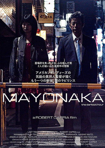 The poster features two men in dark suits standing against a dimly lit, urban backdrop with neon signs and city lights. The mood is mysterious and tense, with the title "Mayonaka" prominently displayed in bold, white letters. The overall color palette is dark with hints of red and blue, creating ...