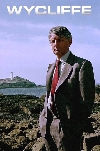A man in a suit stands on rocky cliffs, looking out over a serene seascape. The muted tones of the landscape contrast with his formal attire, creating a contemplative mood.