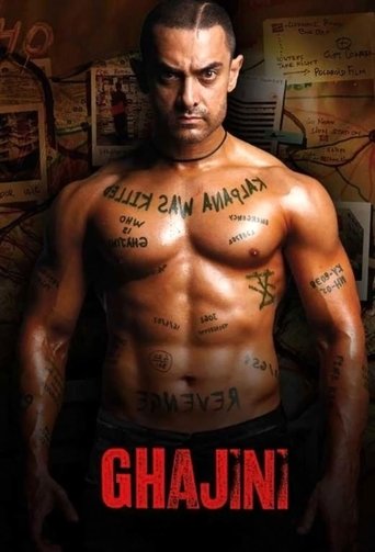 The poster features a muscular man with tattoos, exuding strength and intensity. The warm, golden lighting enhances the dramatic atmosphere. Bold red text at the bottom reads "GHAJINI," suggesting a powerful and intense narrative.