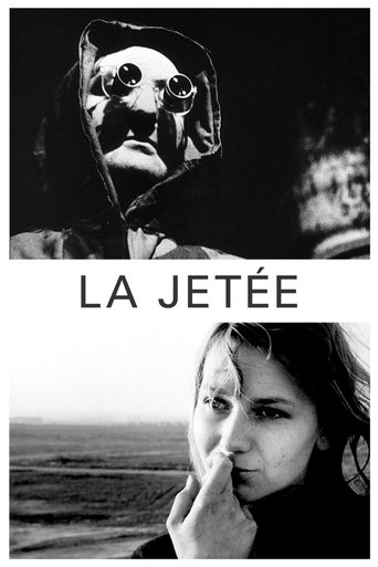 The poster features a hauntingly beautiful black-and-white image of a woman in a hooded cloak, her eyes wide with a sense of mystery. The title "LA JETÉE" is prominently displayed in bold, white letters, evoking a sense of urgency and intrigue. The overall mood is eerie and atmospheric, capturing...