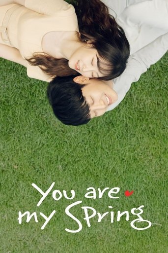 The poster features a tender, close-up shot of two people lying on a vibrant green lawn, their faces turned upward in affection. The warm, soft lighting enhances the intimate mood, while the elegant white script text at the bottom reads "You are my Spring," evoking a sense of love and renewal.