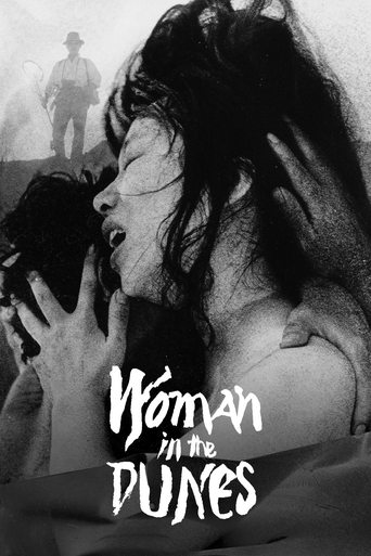 The poster features a haunting black-and-white image of a woman in the foreground, her face contorted in anguish as she holds a child close. In the background, a lone figure stands against a barren, sun-drenched dune landscape, evoking a sense of isolation and tragedy. The title "Woman in the Dun...