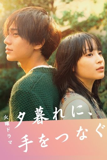 The poster features two young people standing back-to-back, bathed in warm sunset light. The green sweater of the man and the patterned top of the woman create a soft, romantic contrast against the vibrant background. The title "夕暮れに、手をつかなく" (Hold My Hand at Twilight) is prominently displayed in ...