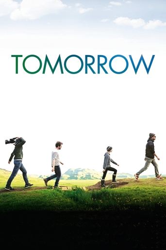 The poster features four children running across a grassy field under a bright sky, evoking a sense of hope and anticipation. The title "TOMORROW" is prominently displayed in bold, teal letters at the top, symbolizing the future. The overall mood is uplifting and energetic, suggesting a journey t...