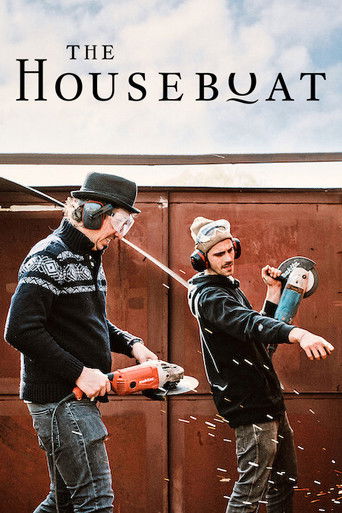 The poster features two men in a rustic, wooden houseboat setting. One man wears a black hat and sweater, while the other sports a beanie and holds a chainsaw. The scene captures a humorous, adventurous mood with splashing water and a bright, sunny atmosphere.