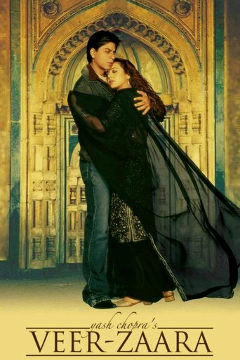 A romantic couple stands in front of an ornate, golden archway, surrounded by rich, warm tones. The man wears a dark, flowing robe while the woman dons a shimmering black dress, creating a striking contrast. The image exudes a sense of intimacy and elegance, capturing a moment of deep connection ...