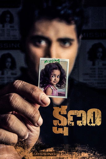 The poster features a dark, moody scene with a man's face partially obscured by shadows. A hand holds up a small card displaying a young girl's face, creating a mysterious and suspenseful atmosphere. The color palette is dominated by dark tones with hints of warm orange, evoking a sense of intrig...