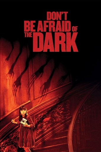 The poster features a young girl in a dark dress standing on a train track, surrounded by ominous red shadows and flames. The title "Don't Be Afraid of the Dark" is prominently displayed in bold red letters at the top. The overall mood is eerie and suspenseful, with a sense of impending danger an...