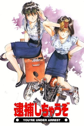 This anime poster features two young women in a playful yet dramatic pose, with one sitting on an orange suitcase and the other leaning against it. The vibrant colors of blue, pink, and red create a lively atmosphere, while the bold red title text at the bottom emphasizes the comedic and action-p...