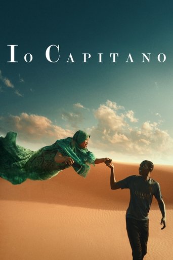 The poster features a man in a dark suit reaching out to a woman in a flowing green dress, set against a vast desert landscape under a bright sky. The warm golden hues of the sand contrast with the cool blue tones of the sky, creating a dramatic and hopeful atmosphere.