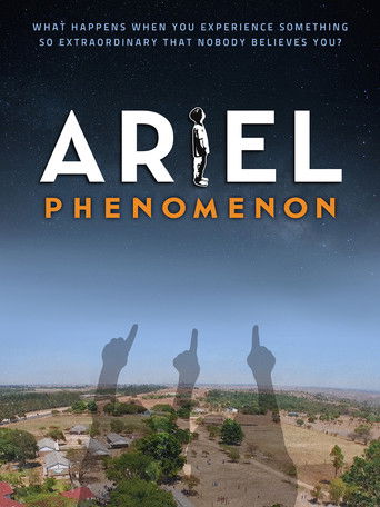 The poster features silhouetted figures against a twilight sky, evoking mystery and intrigue. The title "Ariel Phenomenon" stands out in bold white and orange text, suggesting a blend of wonder and suspense. The desert landscape beneath adds a sense of isolation and natural beauty, hinting at the...