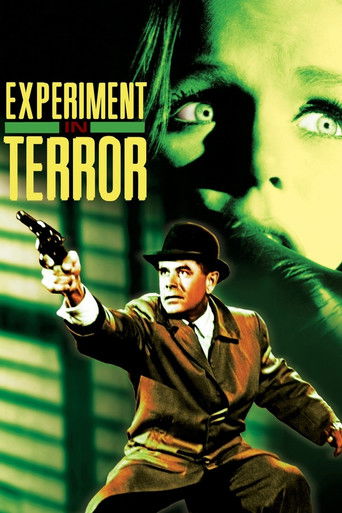 The poster features a man in a bowler hat and trench coat holding a gun, set against a green and yellow background. A large, shadowy face looms in the background, adding to the ominous atmosphere. The colors are vivid, with greens and yellows creating a suspenseful and eerie mood.
