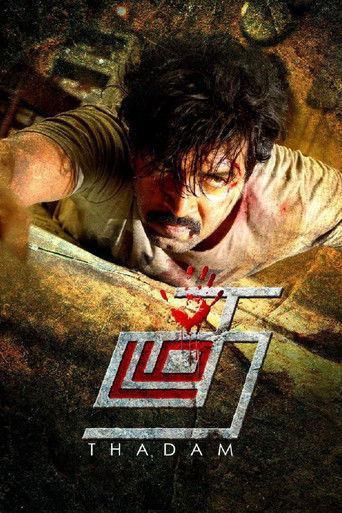 The poster features a distressed man with bloodied hands and a grim expression, conveying intense danger and urgency. The metallic, angular logo of "Thadam" dominates the lower section, with a red burst of energy around it. The overall dark, gritty atmosphere suggests a high-stakes action thriller.