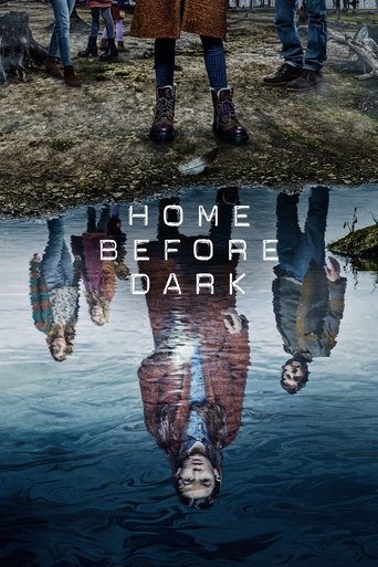 The poster features a split image: the top shows people standing on a grassy hill, while the bottom displays their reflections in dark water. The title "HOME BEFORE DARK" is centered in white text. The muted tones and reflective elements evoke a somber, mysterious mood.