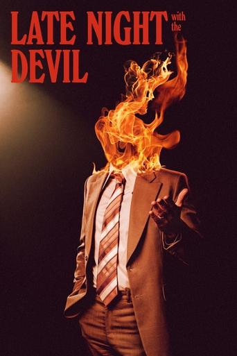 The poster features a man in a suit and tie, his head engulfed in flames against a dark background. The fiery orange and yellow hues dominate the image, creating a dramatic and intense atmosphere. The title "Late Night with the Devil" is prominently displayed in bold red letters at the top.