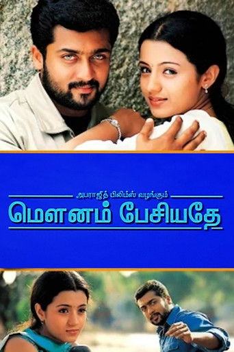 The poster features a romantic couple embracing, with a man in a light shirt and a woman in a white dress. The blue background contrasts with the warm tones of their faces, creating a nostalgic and intimate mood. The title "Mounam Pesiyadhe" is prominently displayed in Telugu script, suggesting a...