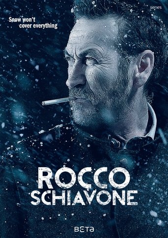 The poster features a rugged man with a cigarette, set against a dark, snowy backdrop. The title "ROCCO SCHIAVONE" is prominently displayed in bold white letters. The overall mood is intense and dramatic, with a cold, wintry atmosphere that hints at a gritty, action-packed storyline.