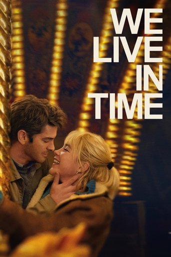 The poster features a romantic couple in a dimly lit theater, their faces close together against warm golden lights. The bold white text "WE LIVE IN TIME" dominates the upper right, evoking a sense of urgency and passion. The mood is intimate yet dramatic, capturing the essence of a timeless roma...