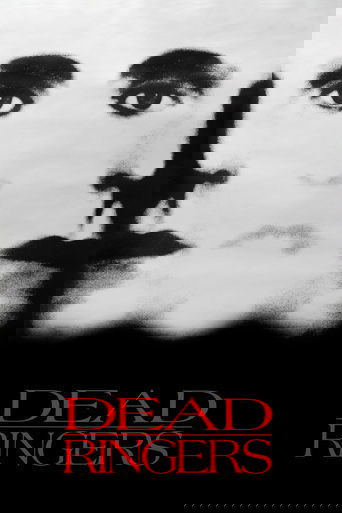 The poster features a haunting, black-and-white close-up of a man's face, emphasizing his eyes and lips. The title "DEAD RINGERS" appears in bold, red letters at the bottom, creating a stark contrast against the monochrome background. The overall mood is eerie and suspenseful, evoking a sense of ...