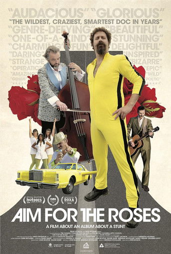 This movie poster features a vibrant yellow and red color scheme, with a man in a yellow outfit standing prominently in the foreground. Surrounding him are various characters, including a woman playing a guitar, a child, and a dog, all set against a backdrop of red roses and a yellow car. The ove...