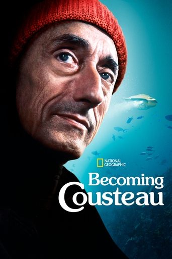 The poster features a close-up of an elderly man with a serious expression, wearing a red knit hat against a deep blue ocean backdrop. The National Geographic logo is subtly placed in the upper right corner, and the title "Becoming Cousteau" is prominently displayed in white text. The overall moo...
